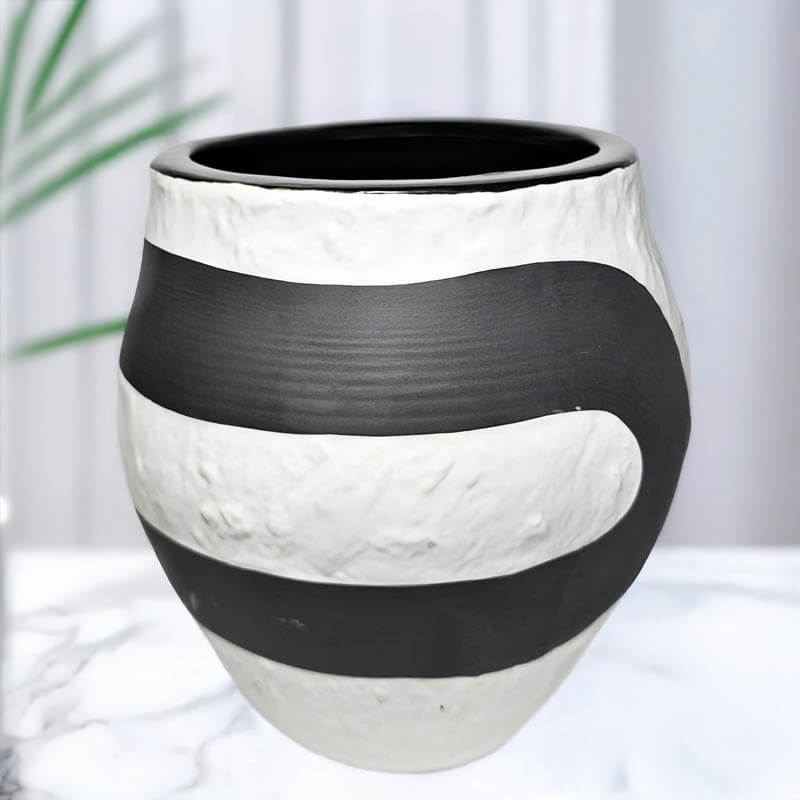 Decorative candle vase with black and white striped pattern on a light background