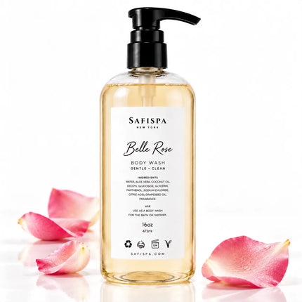 SaFiSpa Belle Rose luxury rose-scented body wash, 16 oz, in a clear pump bottle with a black dispenser, surrounded by pink rose petals on a glossy white background.