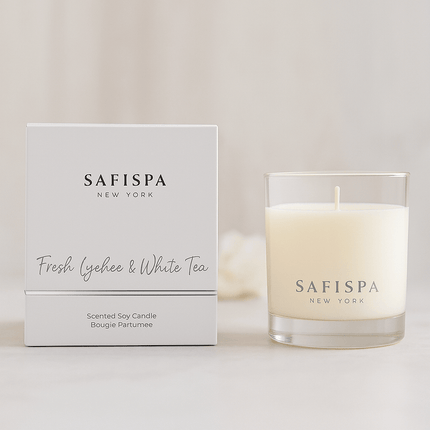 White fresh lychee soy wax candle in a jar with a cotton wick, burning on a table