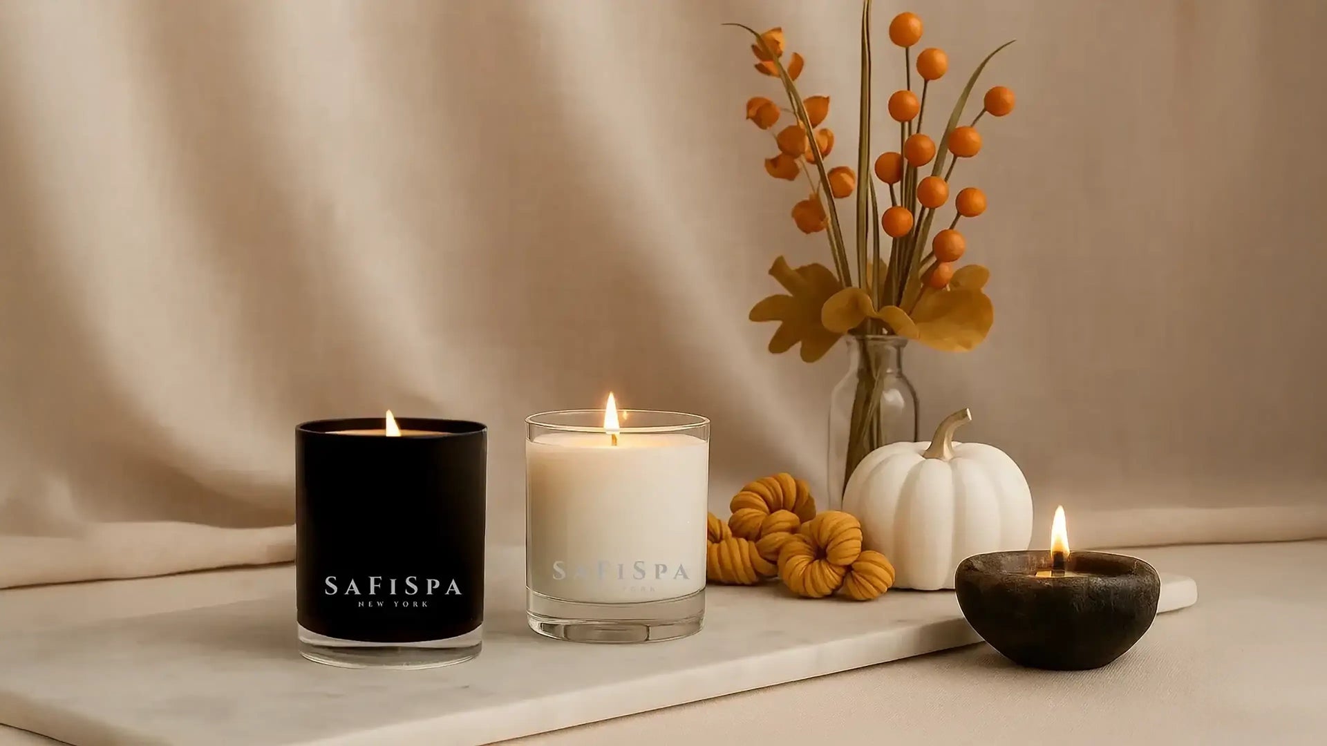 SaFiSpa luxury scented candles with autumn decor, hand-poured soy candles in black and white jars, perfect for cozy home fragrance and fall ambiance.