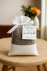 Scented sachet labeled 'Safispa Lavender Vanilla' on a woven stool.