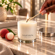 SaFiSpa Fresh Lychee scented candle being lit in an elegant home setting with lychee and white tea