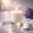 Safispa candle with packaging and lavender flowers on a marble surface