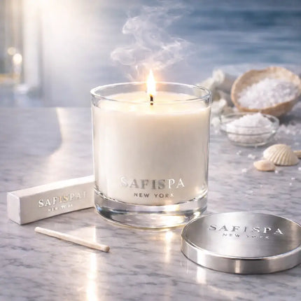 Safispa candle on a marble surface with packaging and sea salt in the background