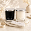 SaFiSpa luxury soy candle collection featuring handcrafted black and white candles with silver lids and premium gift packaging on a marble display