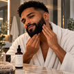 Man applying SaFiSpa Tobacco + Spice beard oil for men to moisturize and condition his beard during his grooming routine.