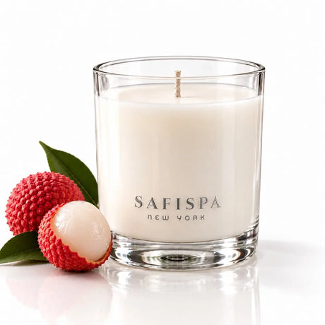 SaFiSpa Fresh Lychee scented soy candle in a clear glass vessel with fresh lychee on a white background.
