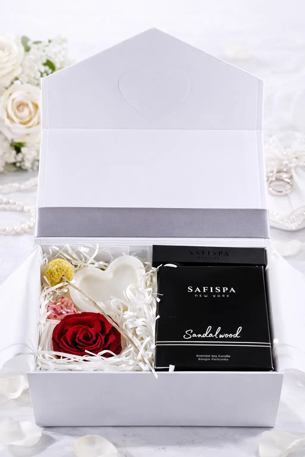 Gift box with flowers and a black box labeled 'SAFISPA' on a white background