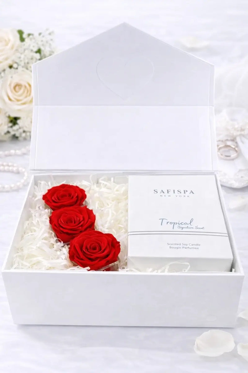 White box with red roses and a product inside, surrounded by white flowers.