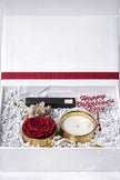 Valentine's Day gift set with a candle, rose, and decorative card in a white box.
