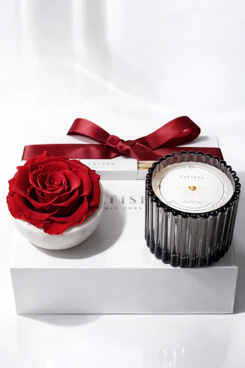 Candle with red rose and bow on a white background