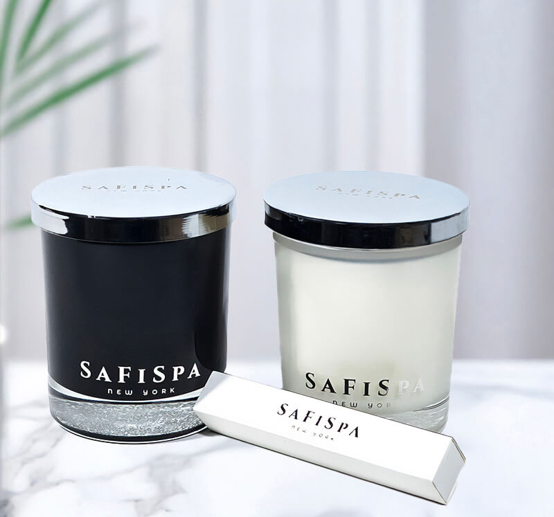 Two candles and match box with 'SAFISPA' branding on a light background.